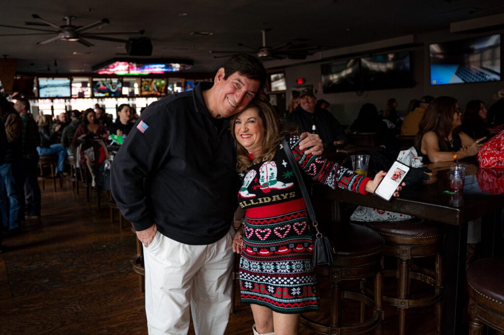 Two guests in holiday attire posing together at Rock the Green Beret